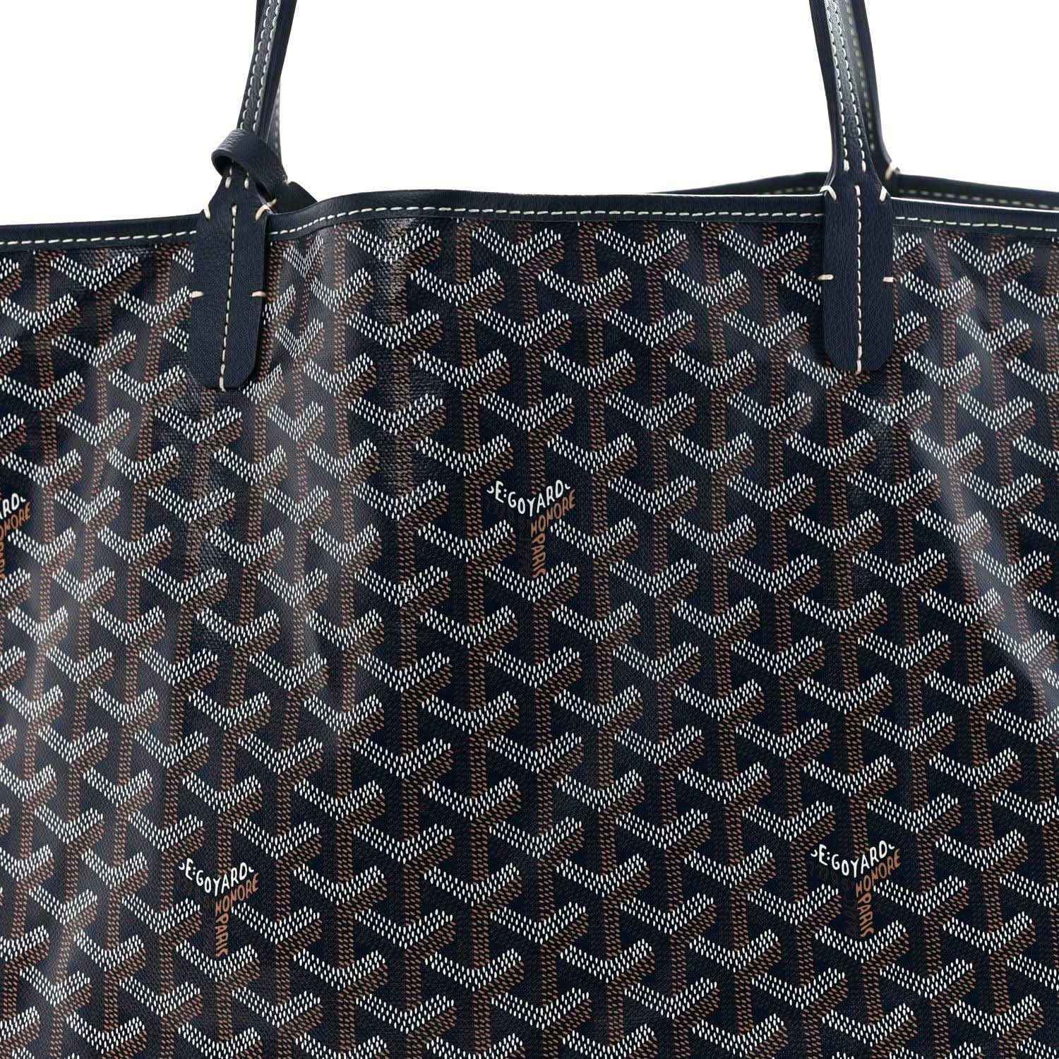 Navy Goyardine tote bag with repeating logo pattern and leather handle stitching.