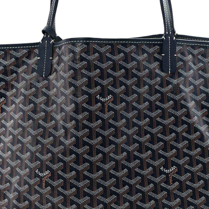 Navy Goyardine tote bag with repeating logo pattern and leather handle stitching.