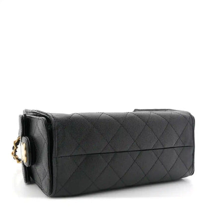 Black quilted mini handbag with side flap, top handle, and metal hardware