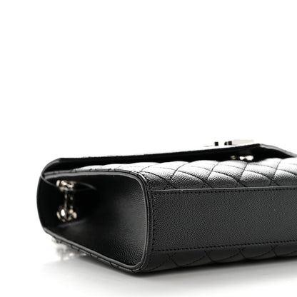 Black quilted satchel side with metal zipper pull and leather edge