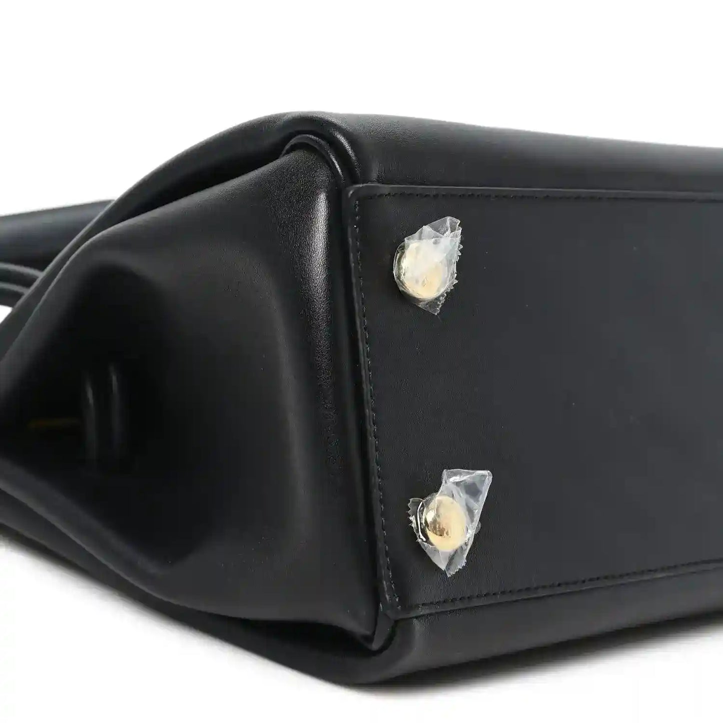 Black leather handbag corner with gold-tone stud detail