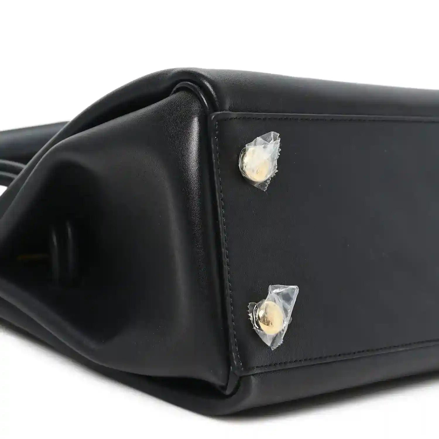 Black leather handbag corner with gold-tone stud detail