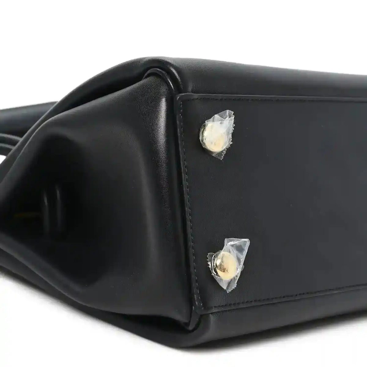Black leather handbag corner with gold-tone stud detail