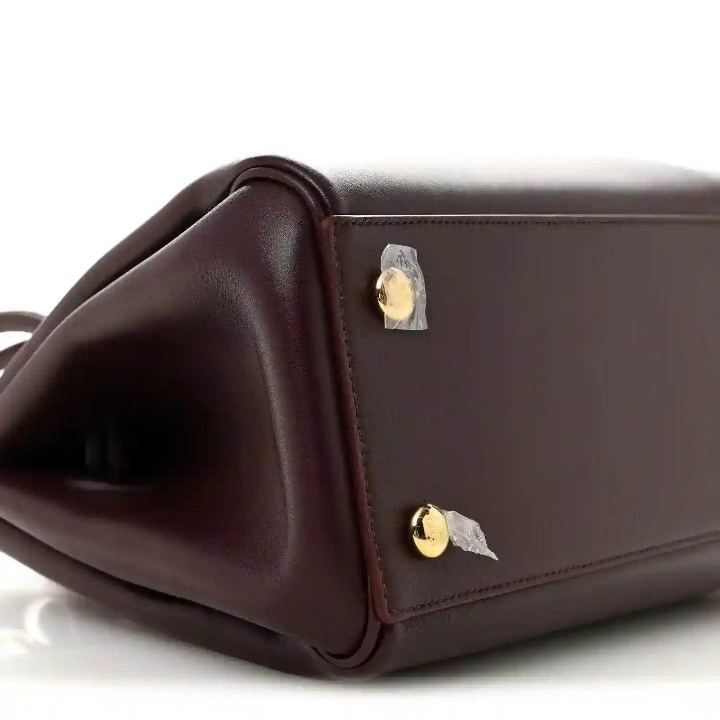 Loewe Small Madrid bag side close-up in dark burgundy calfskin with gold snap hardware