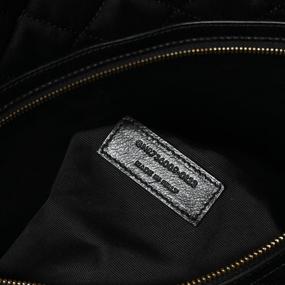 Black leather interior brand label with stamped text and gold zipper trim