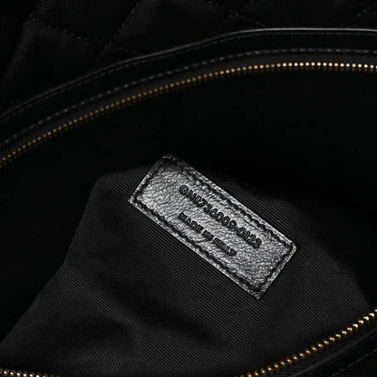 Black leather interior brand label with stamped text and gold zipper trim