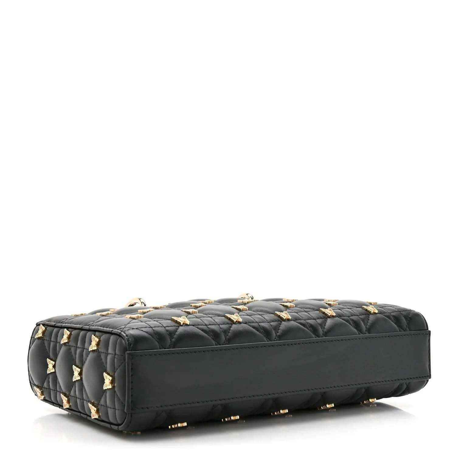 Black quilted handbag with butterfly embellishments and gold accents, side/bottom view