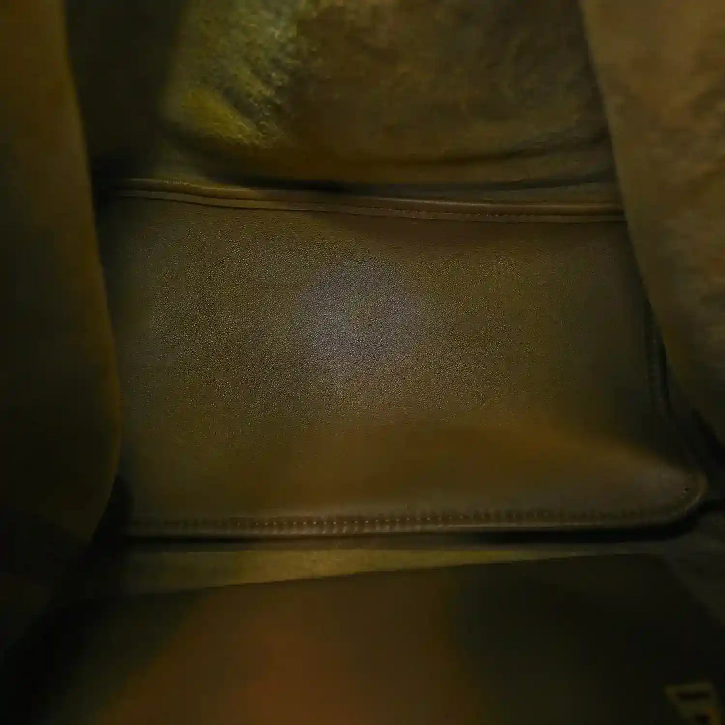 Leather bag interior lining with stitched seam and zipper at the top, dark oak