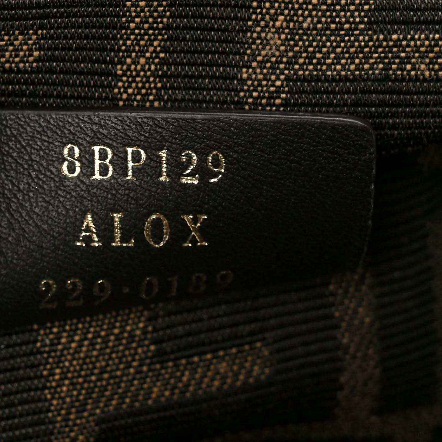 Code label on fabric interior of woven leather clutch bag