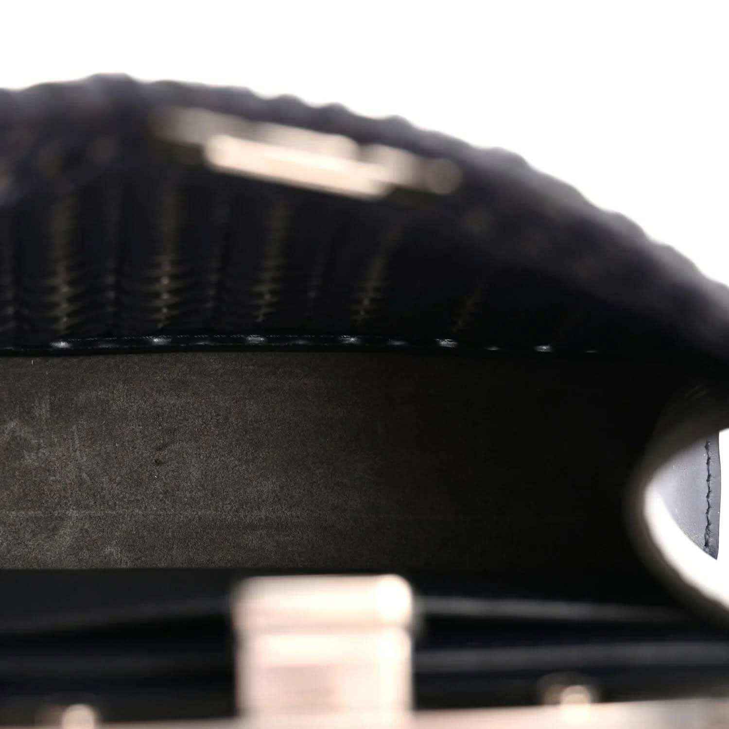 Dark leather interior with textured surface and visible stitching along an inner panel