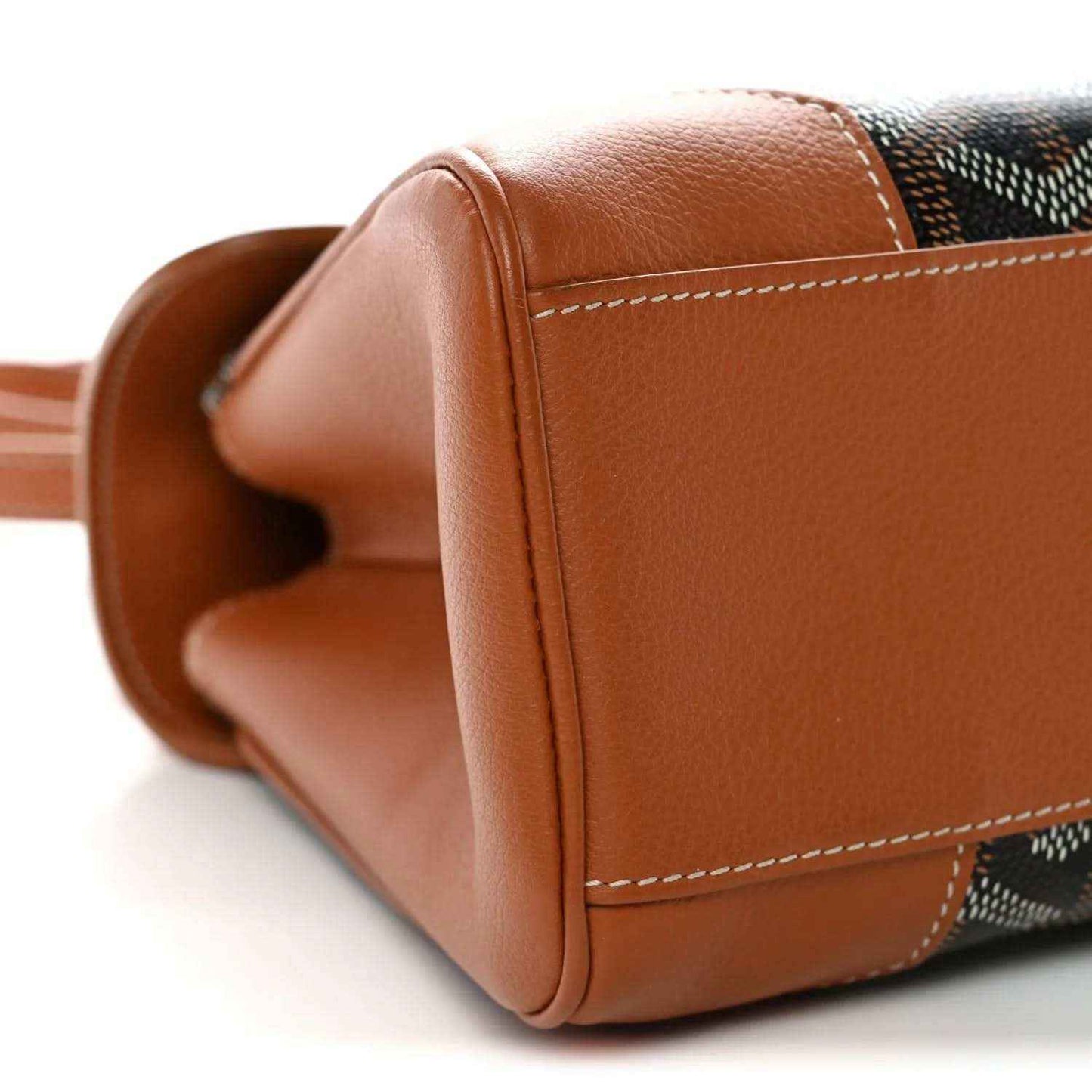 Mini shoulder bag corner with rounded tan leather edge and stitched seam