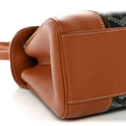 Mini shoulder bag corner with rounded tan leather edge and stitched seam