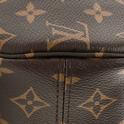 Monogram canvas zipper seam with dark leather trim and crosshatched stitching detail
