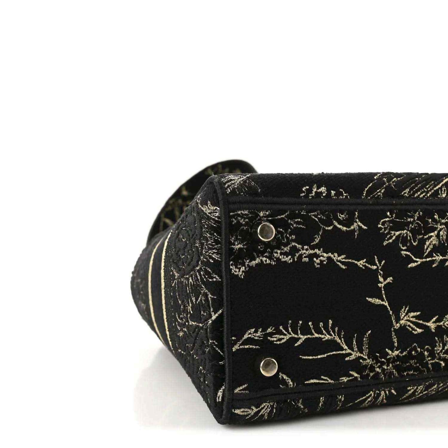 Close-up of black embroidered side panel with gold button snap and trim