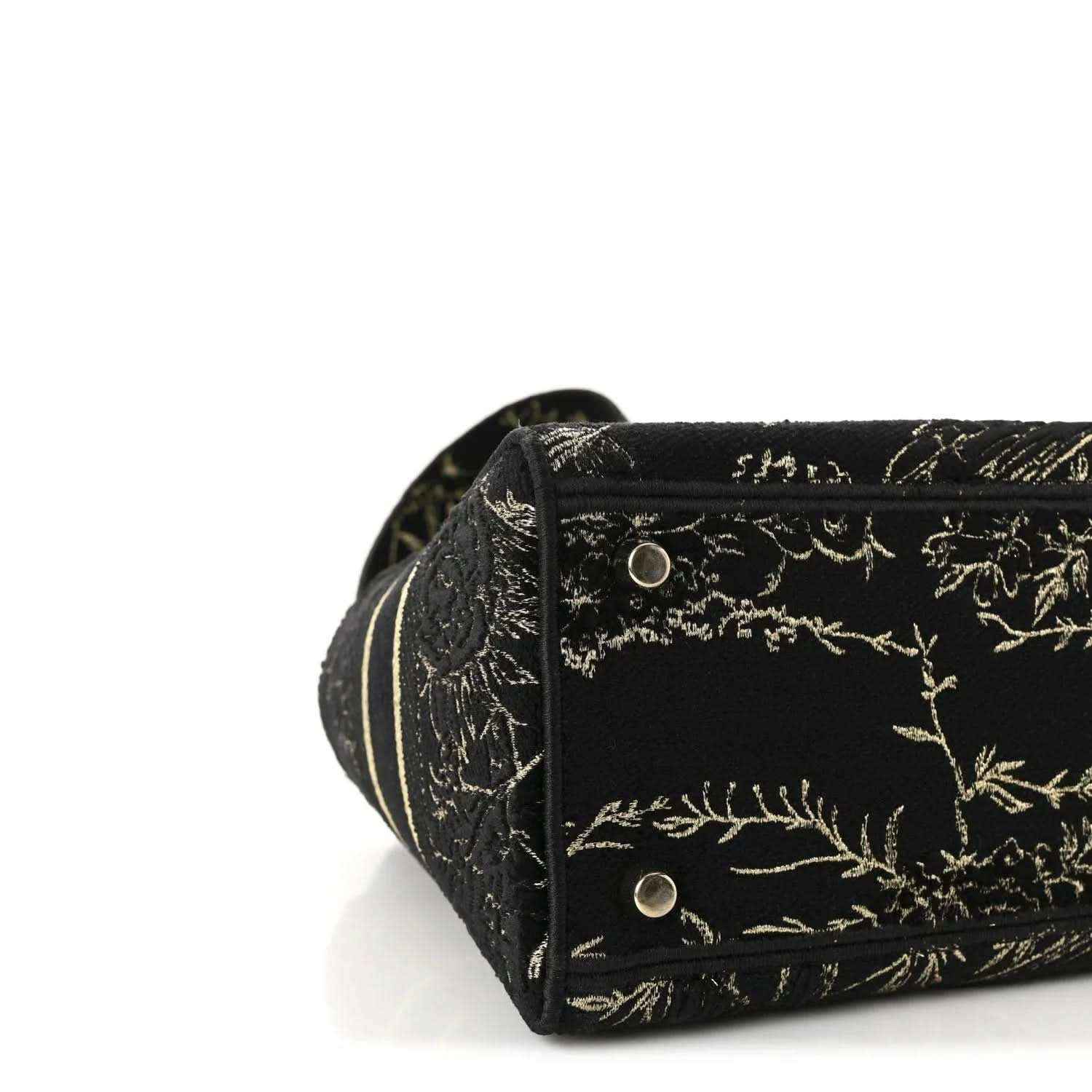 Close-up of black embroidered side panel with gold button snap and trim