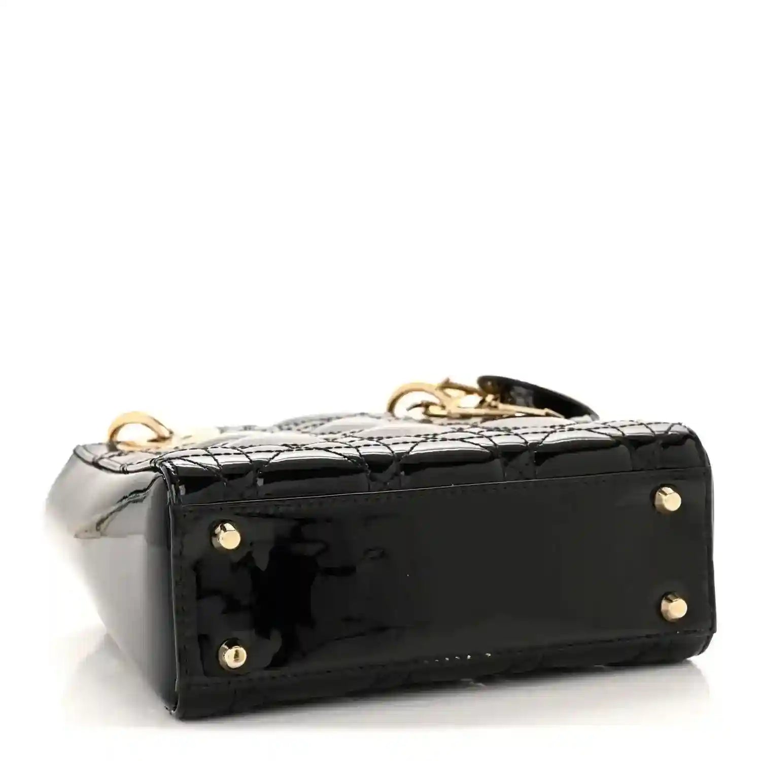 Black patent mini handbag side view with gold feet studs and top handle hardware