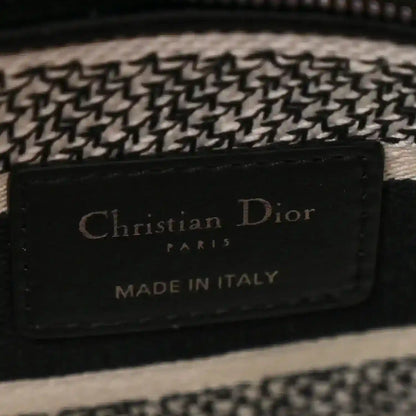 Black leather logo patch reading 'Christian Dior Paris Made in Italy' on houndstooth bag