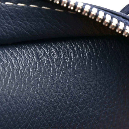 Navy leather with pebbled texture and zipper trim, close-up detail