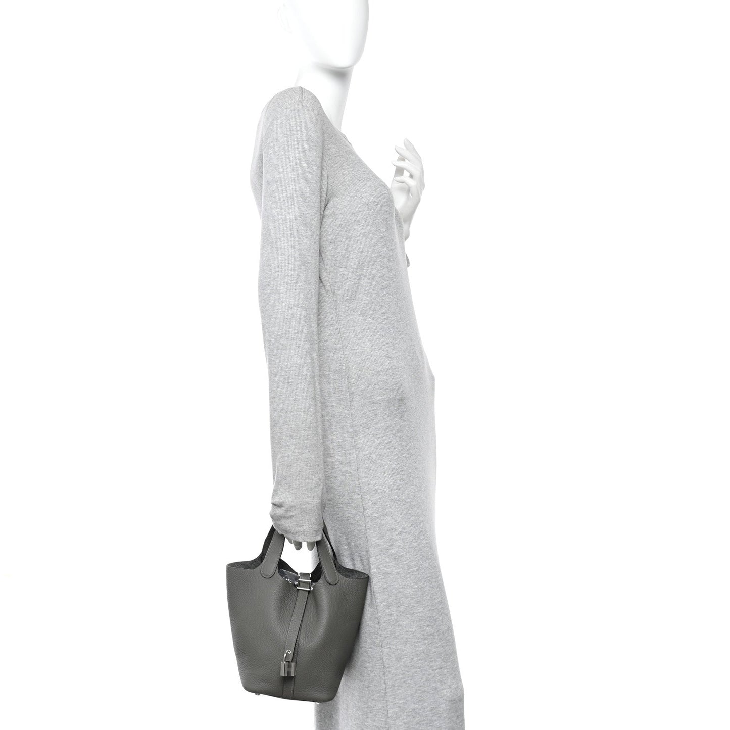 Leather bucket bag on a model’s shoulder, dark green with short top handles