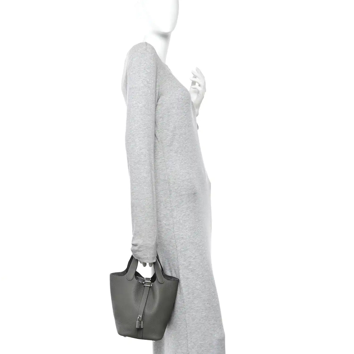 Leather bucket bag on a model’s shoulder, dark green with short top handles