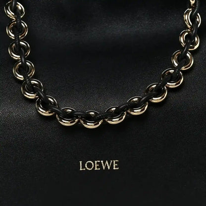 Black leather clutch with chunky gold-tone chain strap and centered LOEWE logo.