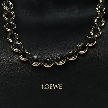 Black leather clutch with chunky gold-tone chain strap and centered LOEWE logo.