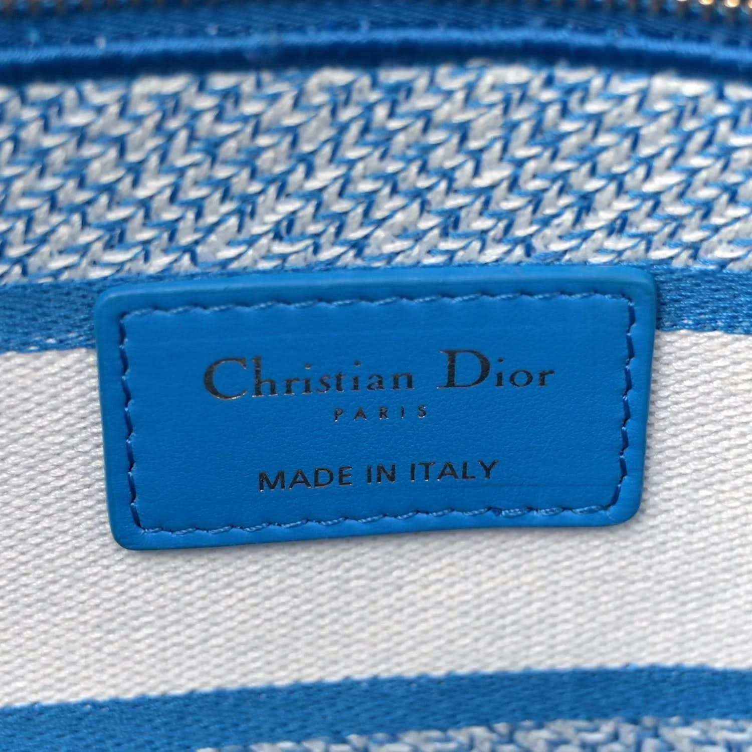 Blue-and-white embroidered bag interior label reading Christian Dior Paris, made in Italy.