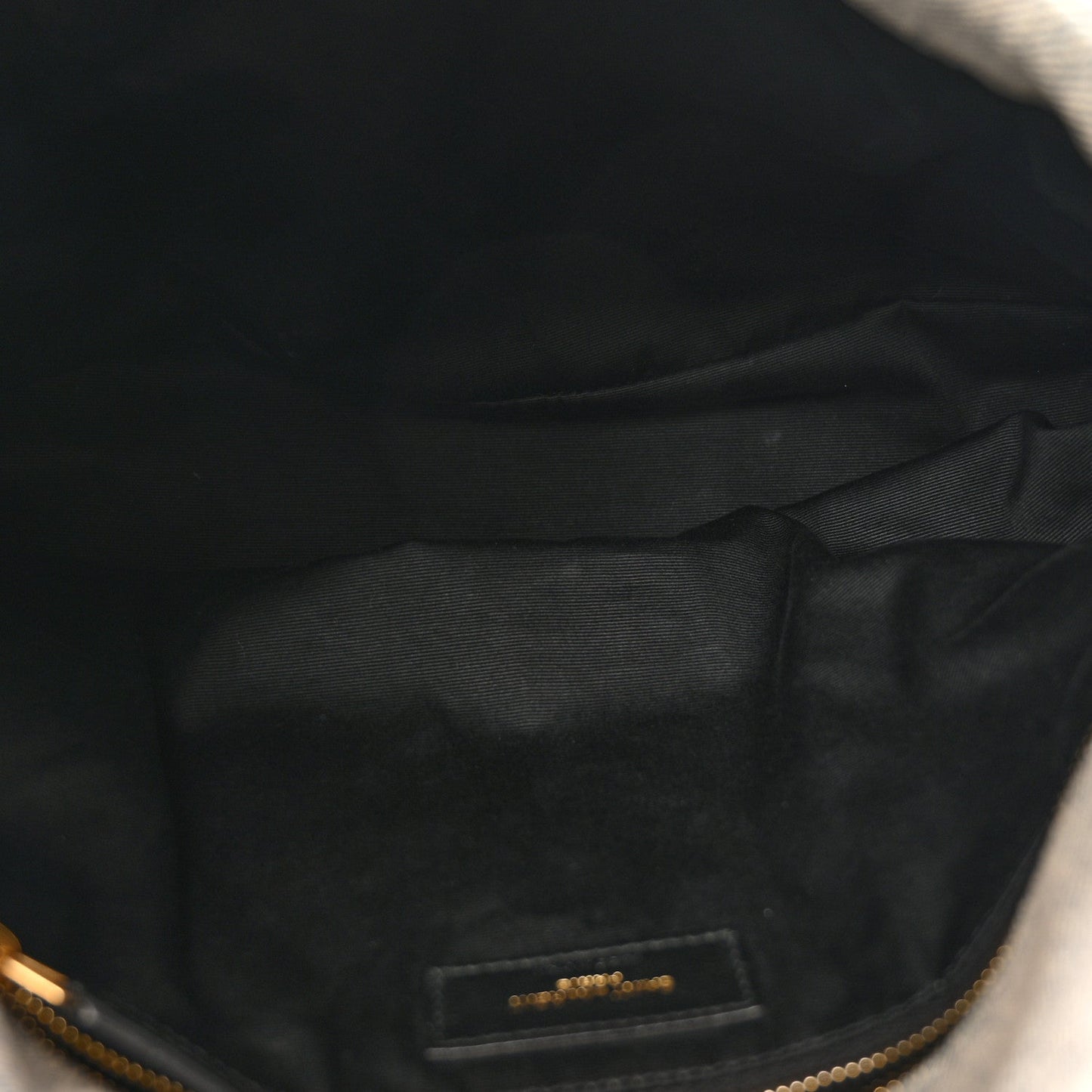Interior lining close-up with brand label on quilted satchel