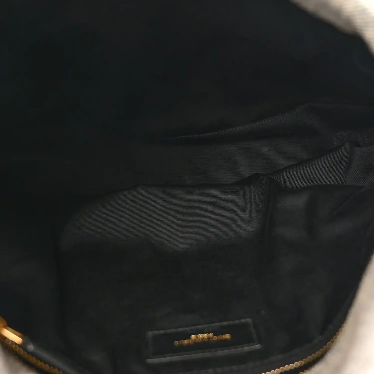 Interior lining close-up with brand label on quilted satchel