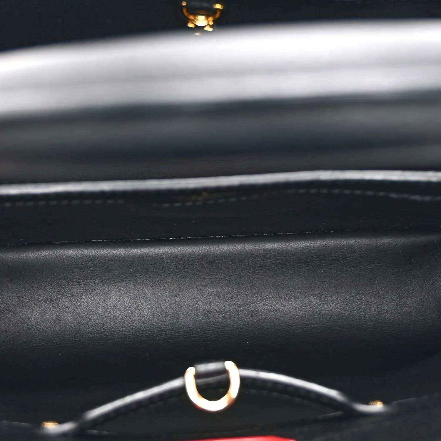 Black handbag leather with silver ring strap hardware and gold accent detail
