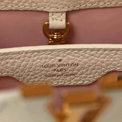 Louis Vuitton Paris label on beige leather handbag with gold clasp detail