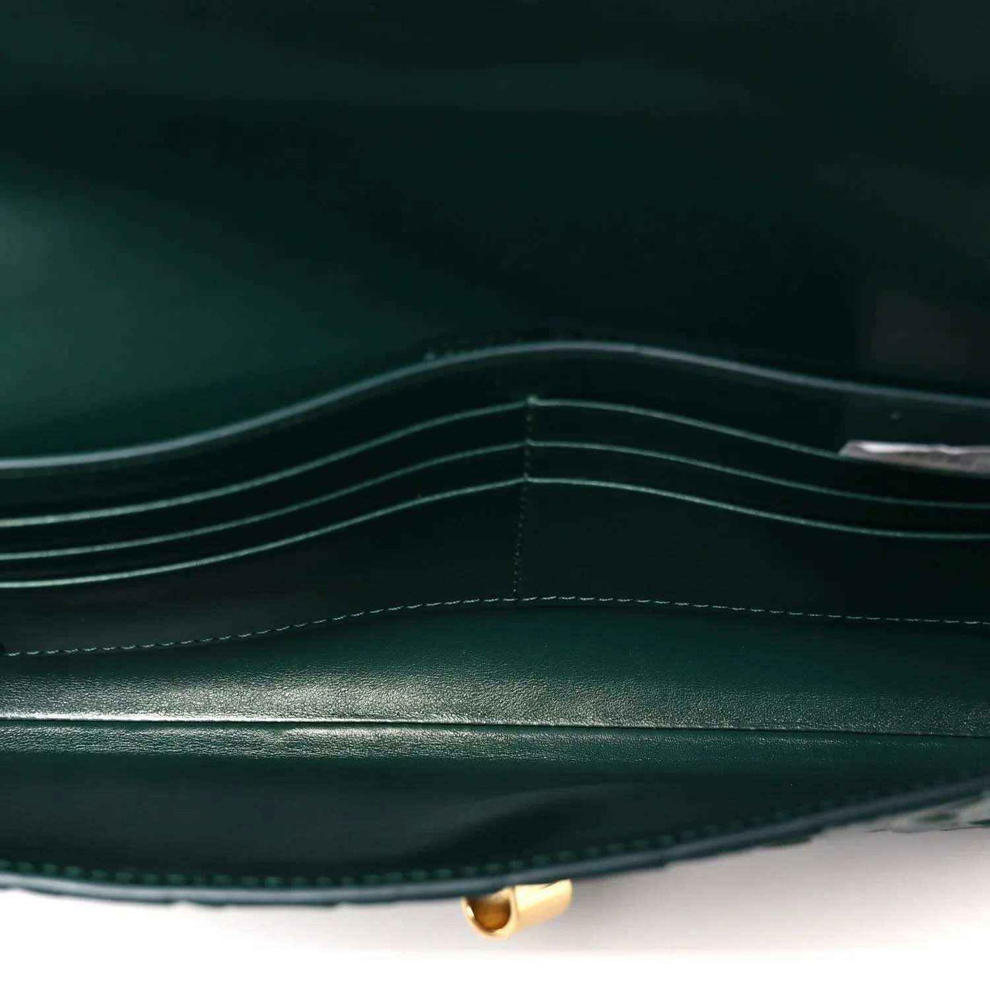 Emerald green clutch bag interior with stitched compartments and gold clasp base