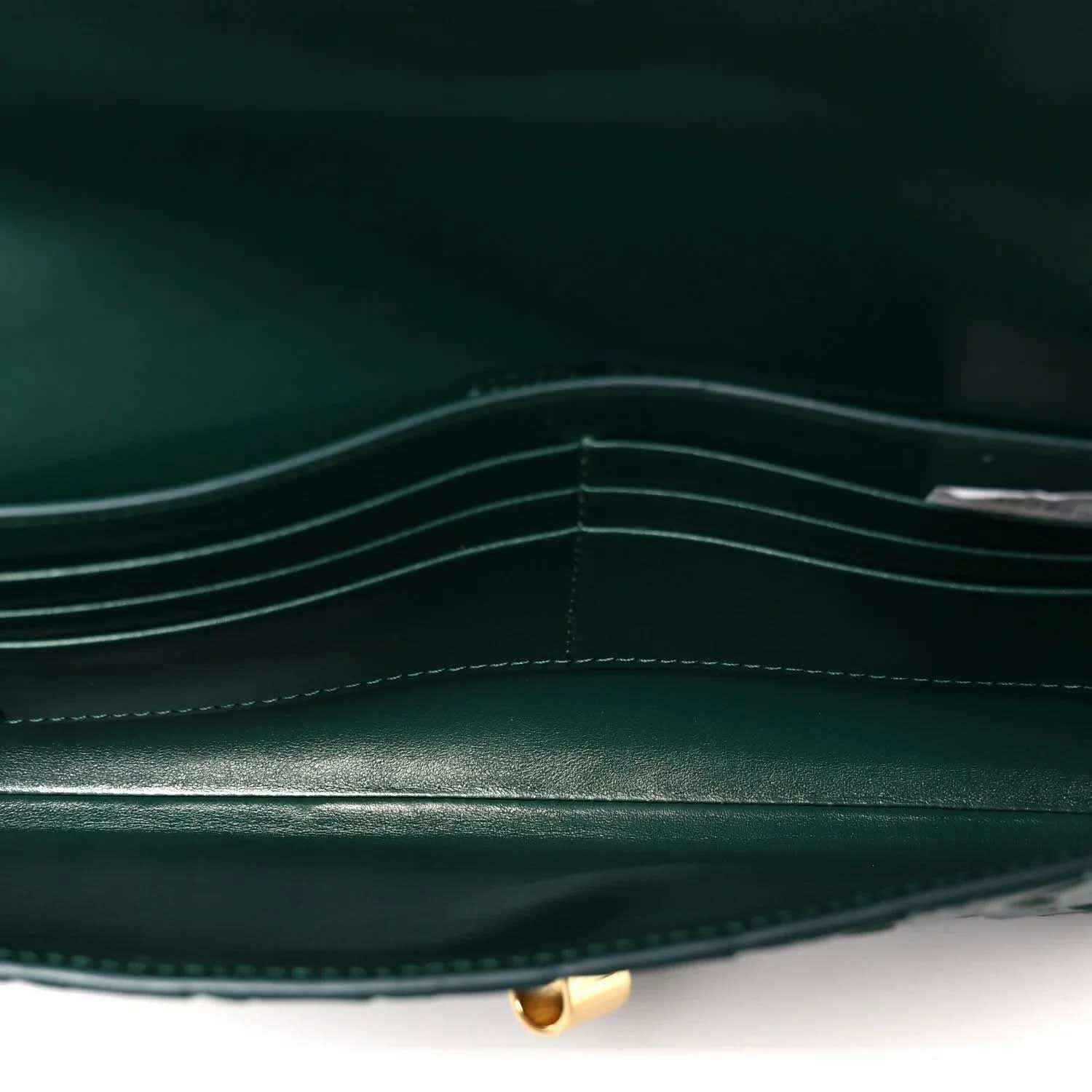 Emerald green clutch bag interior with stitched compartments and gold clasp base