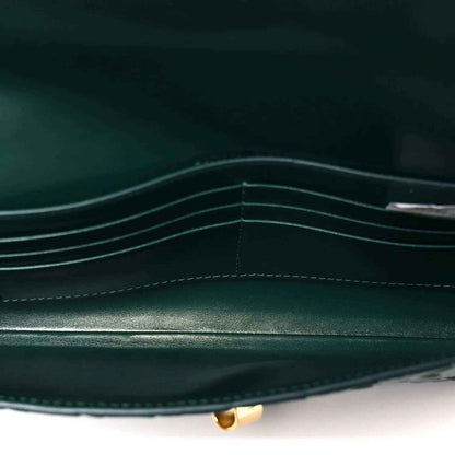 Emerald green clutch bag interior with stitched compartments and gold clasp base