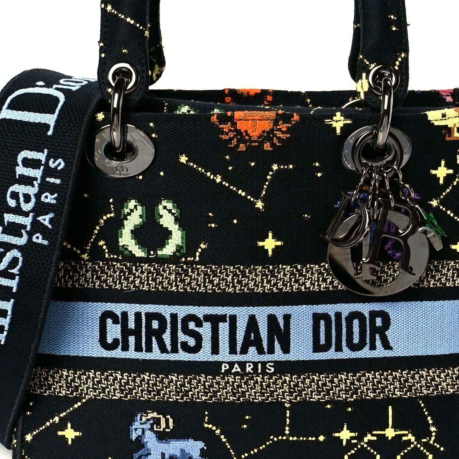 Front view handbag with CHRISTIAN DIOR PARIS logo, zodiac pixel print and metal charms