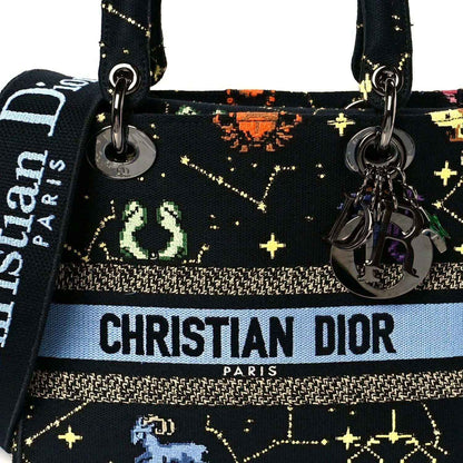 Front view handbag with CHRISTIAN DIOR PARIS logo, zodiac pixel print and metal charms