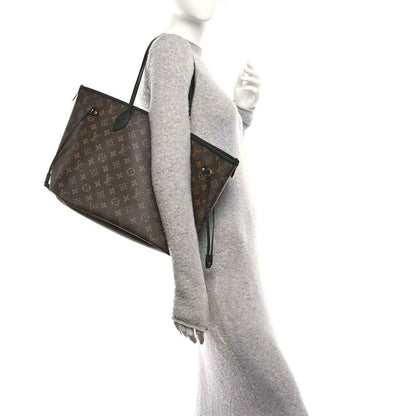 Monogram tote bag with leather straps, angled view and side pocket