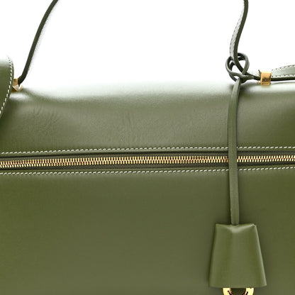 Olive green leather handbag with gold zipper track and hanging leather tassel charm