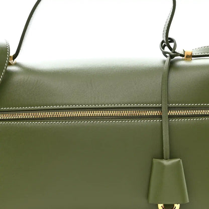 Olive green leather handbag with gold zipper track and hanging leather tassel charm