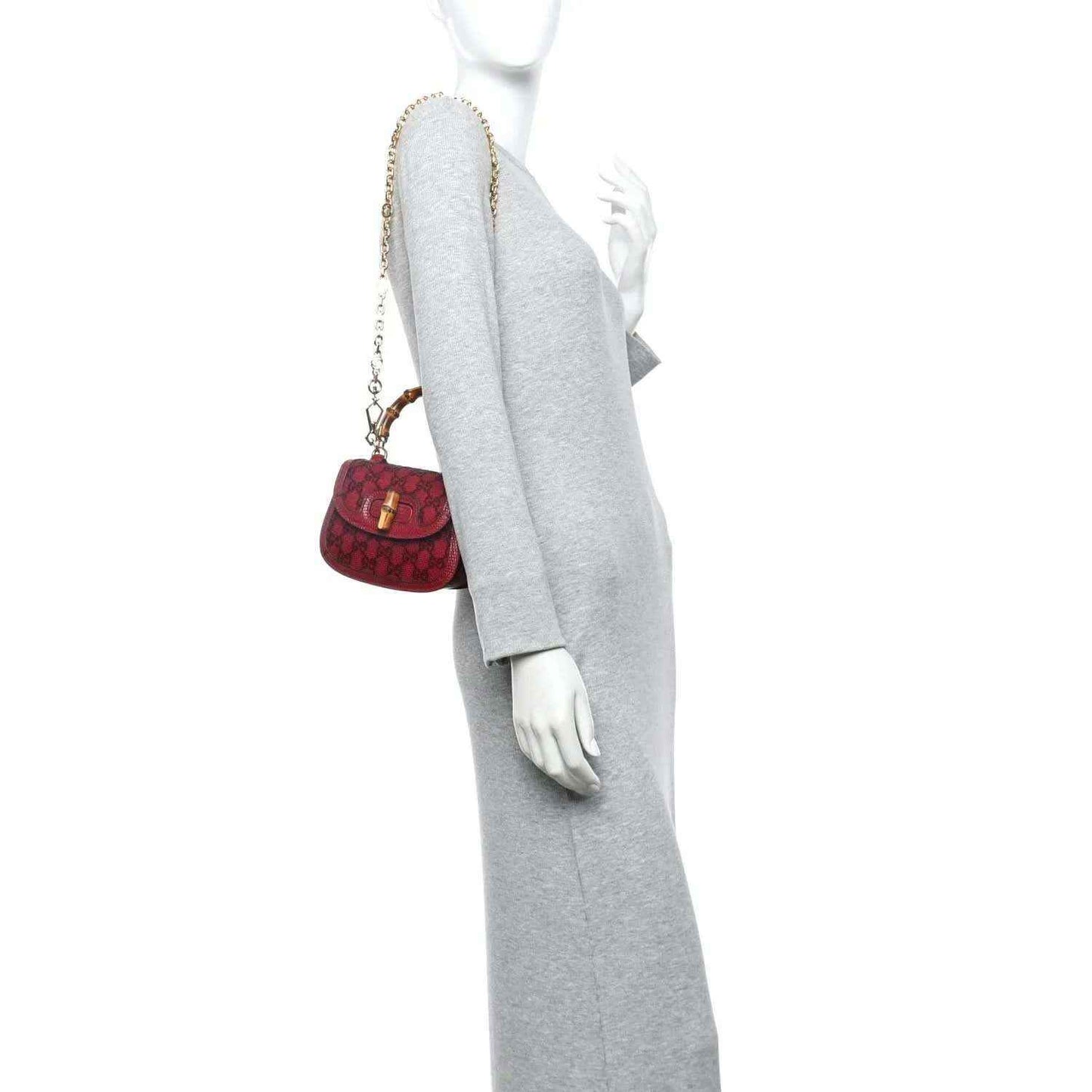 Red mini top-handle bag worn across shoulder with a gold chain strap and bamboo-look handle.