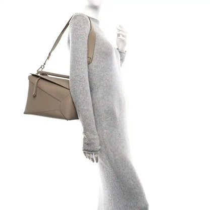 Sand leather bag shown from side with long strap and adjustable strap hardware.