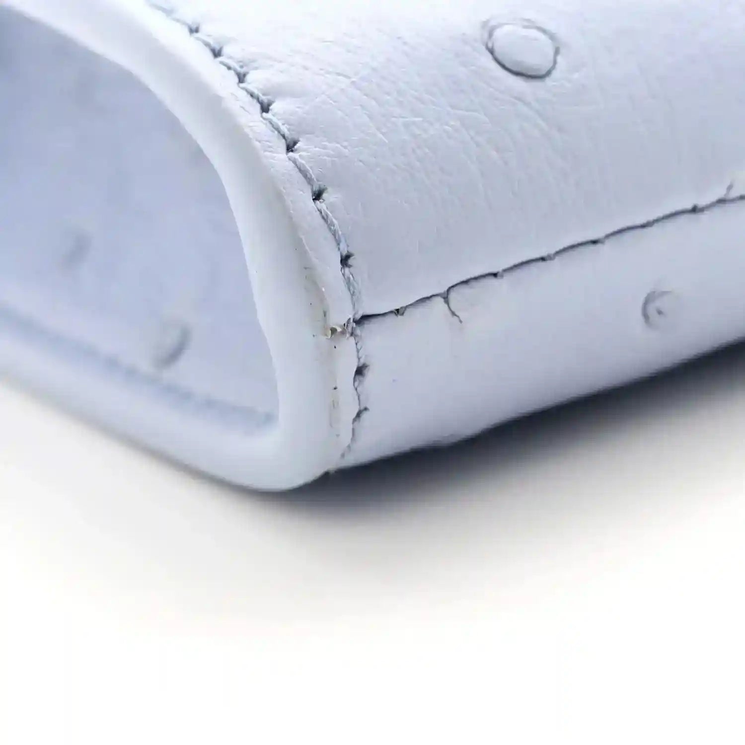 Light blue ostrich leather clutch bag, stitched corner and rounded edge