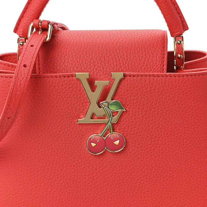 Red leather mini handbag front with LV cherry charm and gold-tone clasp hardware.