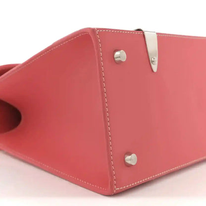 Pink canvas bag corner with silver snap hardware and contrast stitched leather trim.