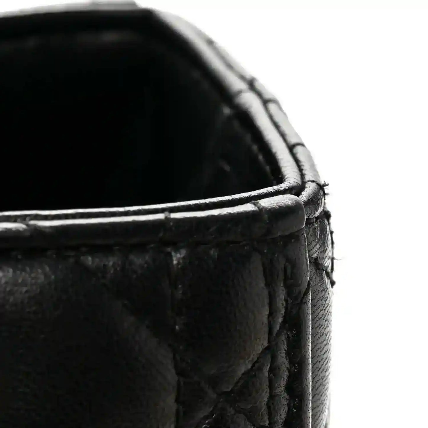 Black quilted leather handbag close-up of top edge and braided trim