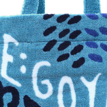 Turquoise tote front panel with black leopard-style spots and white graphic lettering.