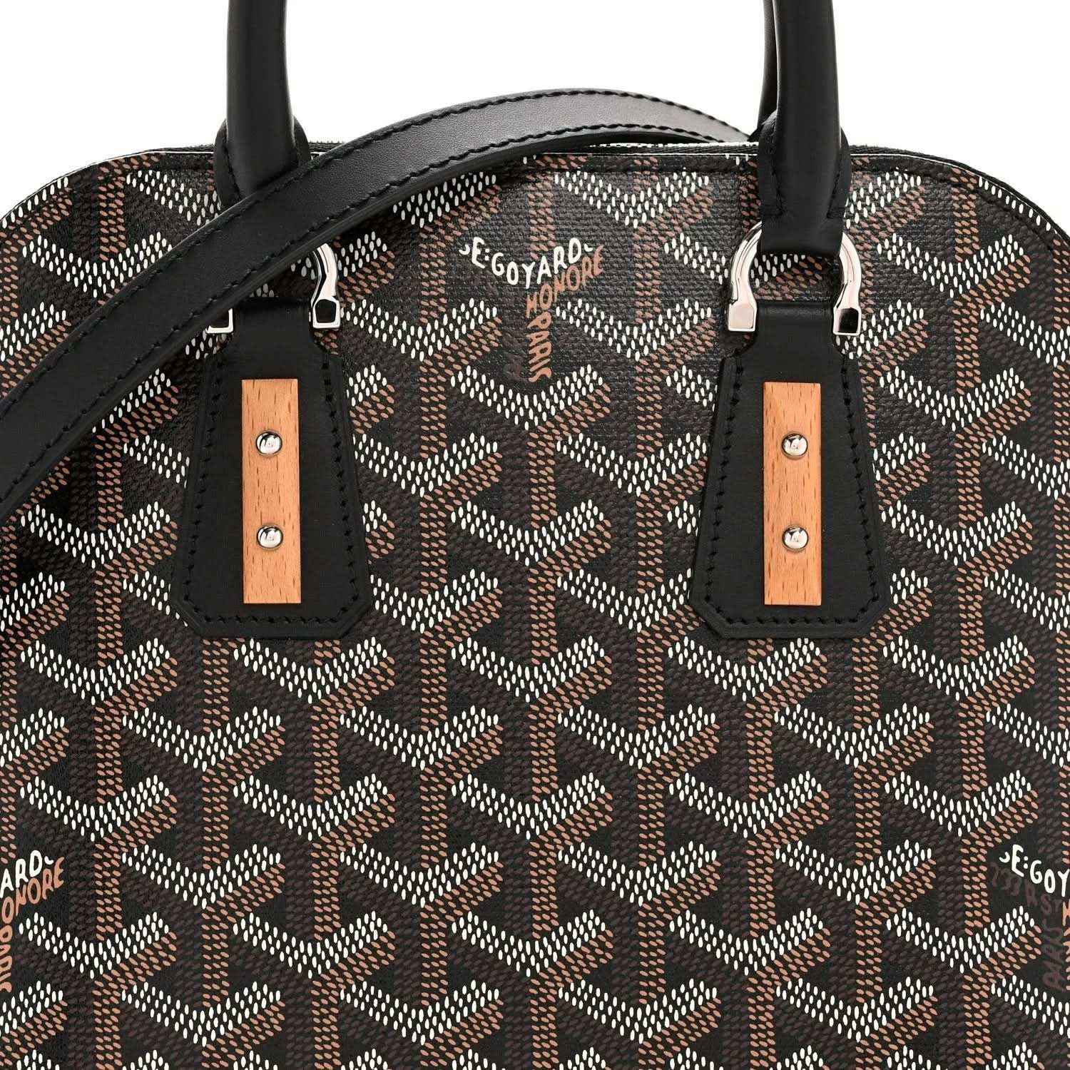 Mini handbag front detail: monogram canvas, black straps with tan leather tabs