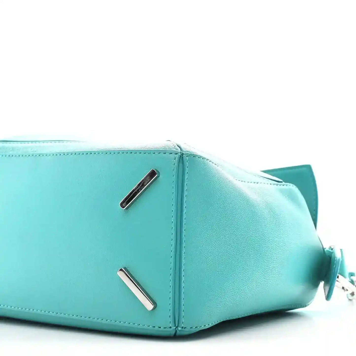 Teal-blue small Puzzle bag side view with metal bar accents and zip opening edge.