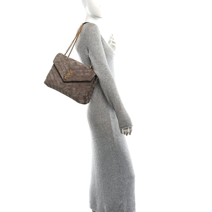 Taupe quilted suede satchel with gold chain strap shown on a model
