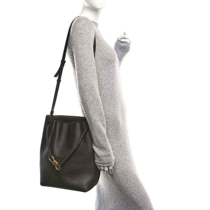 Small bucket bag in dark leather with crossbody strap and gold-tone clasp